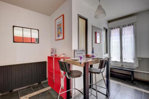 - une cuisine avec un îlot rouge dans une chambre dans l'établissement T1 Confortable avec parking, proche Lyon, Idéal couples ou travailleurs, à Corbas