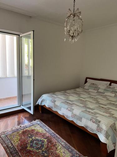 a bedroom with a bed and a chandelier at Montenegro Seaside Lux Apartment in Petrovac na Moru
