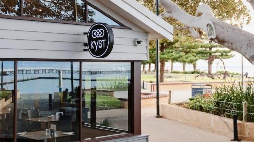 a restaurant with a sign on the side of a building at Serenity by the Sea in Busselton