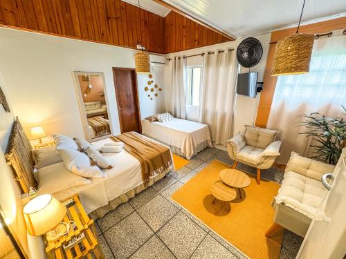 a bedroom with a bed and a chair in a room at Pousada Surf na Guarda in Guarda do Embaú