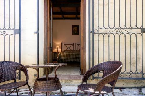 a patio with two chairs and a table and a fence at Agriturismo Baglio Fontana in Buseto Palizzolo