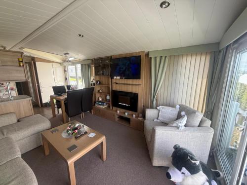 a living room with a couch and a table at Oceanretreatholidays in Burry Port