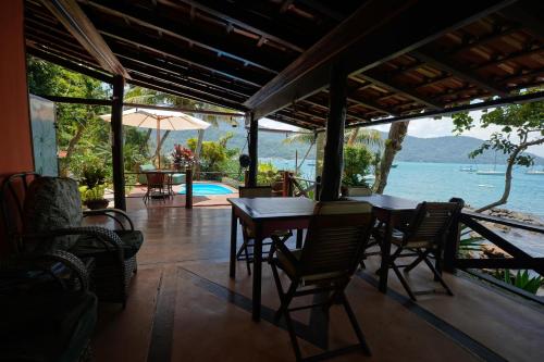 a dining room with a table and chairs and a view of the water at Casa da Ilha & SPA in Abraão