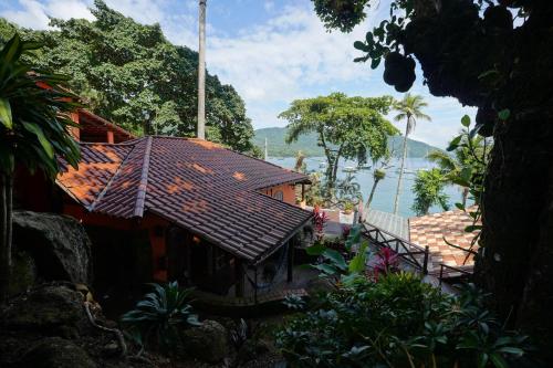 a house with a tiled roof next to the water at Casa da Ilha & SPA in Abraão