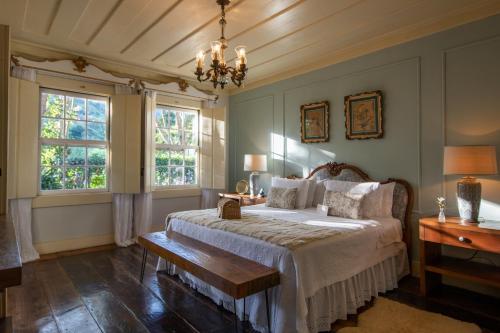 a bedroom with a bed and two windows at Hotel Fazenda União in Rio das Flores