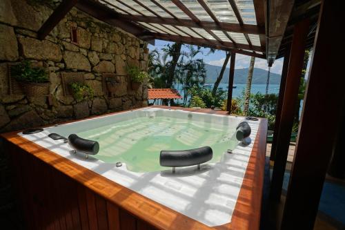 a jacuzzi tub with two black chairs in it at Casa da Ilha & SPA in Abraão