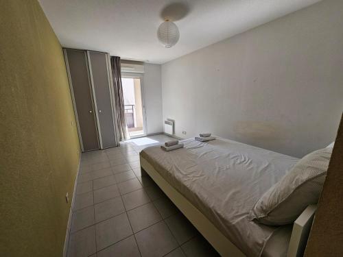une chambre avec un lit et une grande fenêtre dans l'établissement Appartement spacieux au cœur d'Avignon, à Avignon