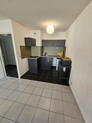 Il comprend une grande cuisine avec un comptoir et du carrelage. dans l'établissement Appartement spacieux au cœur d'Avignon, à Avignon