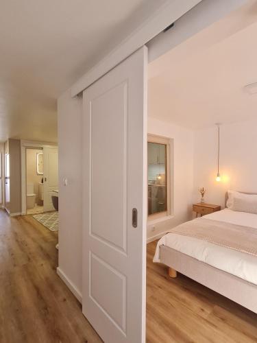 a bedroom with a bed and a sliding door at Alba Odeceixe - casa baixa in Odeceixe