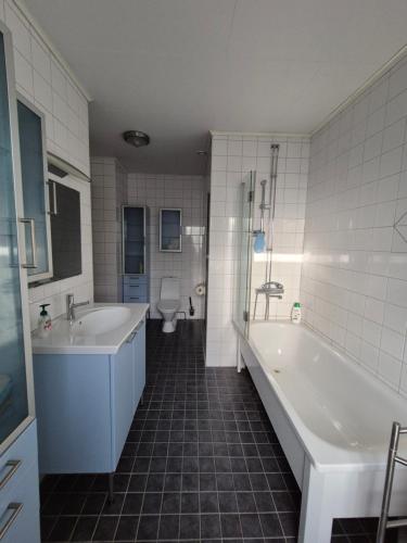 a bathroom with two sinks and a tub and a toilet at Vacker villa nära Kolmården och Norrköping in Åby