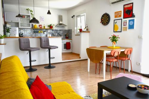 a living room with a table and chairs and a kitchen at Luna House in Sutivan