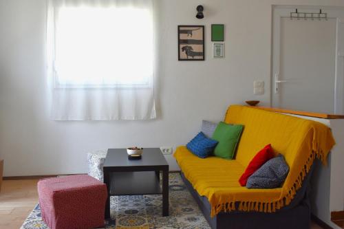 a living room with a yellow couch and a table at Luna House in Sutivan