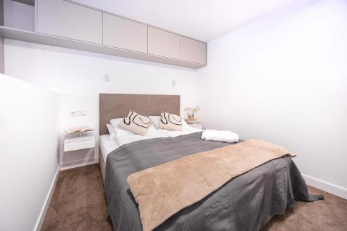 a bedroom with a large bed with two pillows on it at Yoga Zen, apartament z tarasem i widokiem na park in Łódź