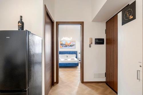 a hallway with a refrigerator and a room with a bed at Italian Essence - Bergamo Center in Bergamo