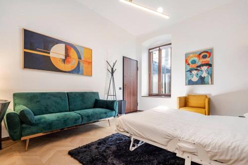 a bedroom with a green couch and a bed at Italian Essence - Bergamo Center in Bergamo