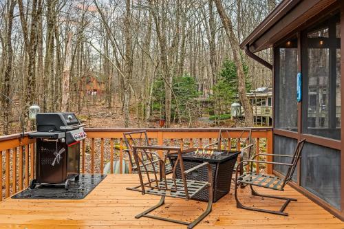 a deck with a table and chairs and a grill at Atlas Point Lodge Sauna Fireplaces Kayaks Lakes Pet-Friendly Yard in Pocono Lake