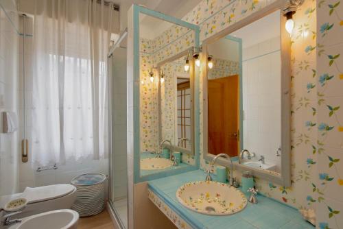 a bathroom with two sinks and a large mirror at Porto Santo Stefano Panoramic Penthouse in Porto Santo Stefano