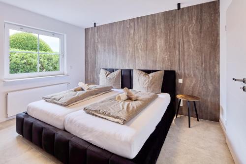 two large beds in a bedroom with a window at Ferienwohnung Auszeit in Attendorn