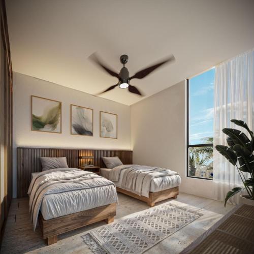 a bedroom with two beds and a ceiling fan at Aytana Luxury Living in Chuburná