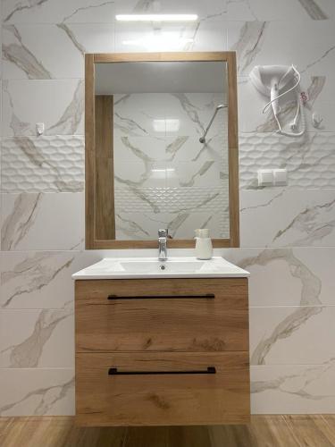 a bathroom with a sink and a mirror at MAGURSKA PANORAMA l samodzielne zameldowanie l self check-in in Chrząstówka