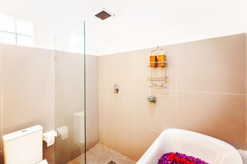 a bathroom with a bath tub and a toilet at Villa Mewah di Nusa Penida in Nusa Penida