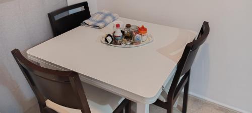 a table with two chairs and a white table with bottles on it at Apartamento Turístico Playa Alborán Sur in Melilla