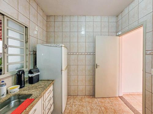 a kitchen with a refrigerator and a sink at POUSADA NOVA BARãO in Campinas