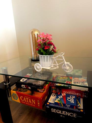 a glass table with books and a vase with flowers on top at Downtown Huntsville Gem in Muskoka in Huntsville