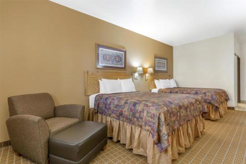 a hotel room with two beds and a chair at Best Western Gold Canyon Inn & Suites in Gold Canyon