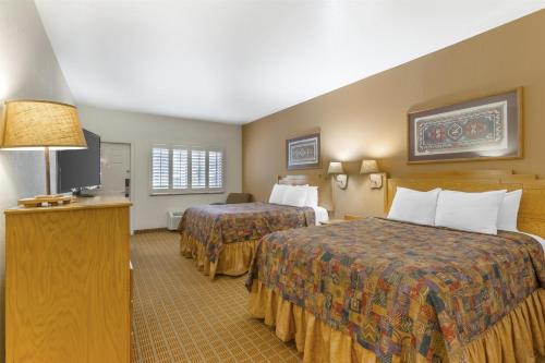 a hotel room with two beds and a television at Best Western Gold Canyon Inn & Suites in Gold Canyon