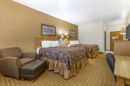 a hotel room with two beds and a chair at Best Western Gold Canyon Inn & Suites in Gold Canyon