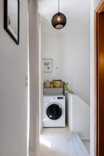 a laundry room with a washing machine in a hallway at La Hacienda cozy home in Pigi