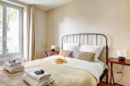 une chambre avec un grand lit avec des serviettes dessus dans l'établissement Suite Auffret Cosy studio, à Pantin
