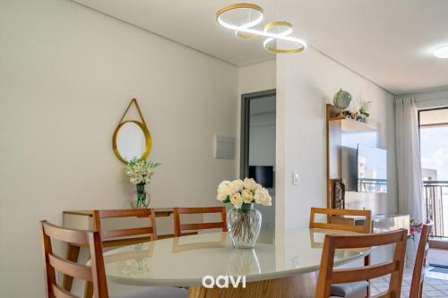 a dining room with a table with chairs and a mirror at Flats Confortáveis em Manaíra Mindset - Qavi in Tambaú