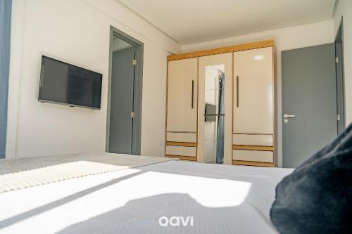 a bedroom with a bed with a tv on the wall at Flats Confortáveis em Manaíra Mindset - Qavi in Tambaú