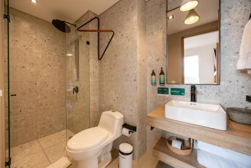 a bathroom with a toilet and a sink and a shower at Landmark Hotel in Medellín