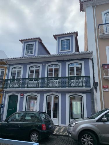 a blue house with cars parked in front of it at Casa da Joana T2 no Centro Histórico de Angra in Angra do Heroísmo