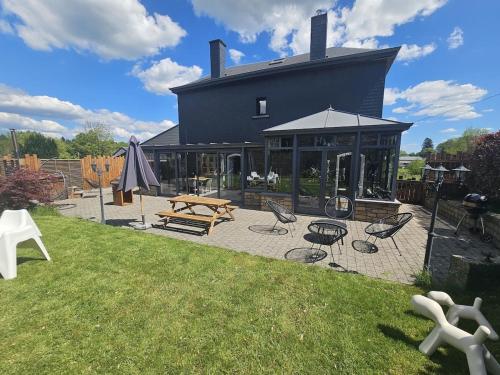 a black house with a picnic table and chairs at Luxury Gites Les Balaux in Sainte-Marie