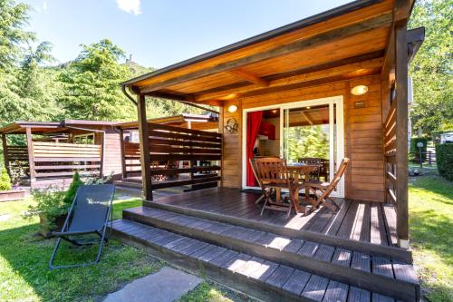 a wooden cabin with a table and chairs on a deck at Bijoux Des Alpes - Mont Blanc Village in La Salle