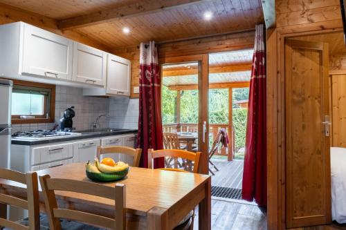 a kitchen with a table with a bowl of fruit on it at Bijoux Des Alpes - Mont Blanc Village in La Salle
