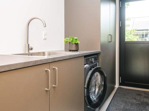 a kitchen with a washing machine and a sink at 6 person holiday home in Juelsminde-By Traum in Sønderby