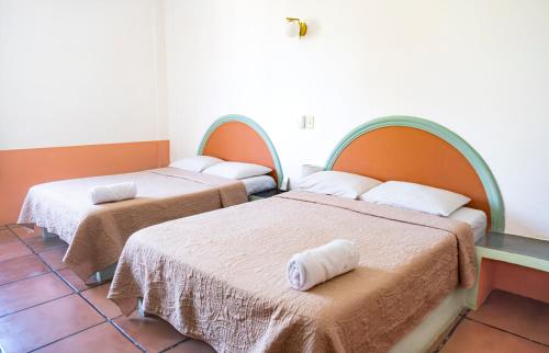 a room with two beds in a room at Hotel Flor de Maria in Puerto Escondido