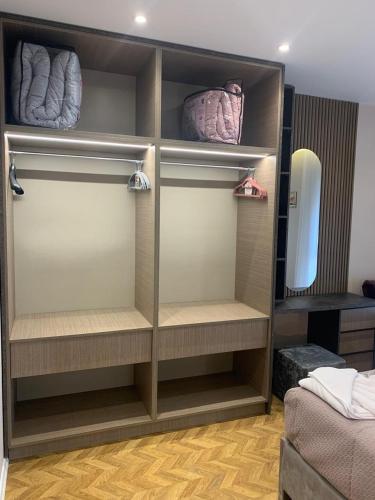 a walk in closet with shelves and a bed at Tirana Magnifique Apartments in Tirane