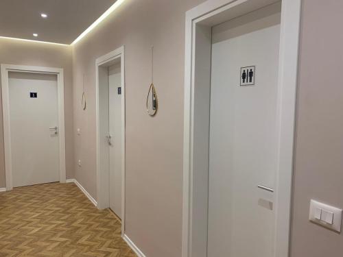 a hallway with white walls and doors with the number at Tirana Magnifique Apartments in Tirane