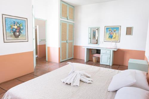 a room with a bed with white gloves on it at Hotel Flor de Maria in Puerto Escondido