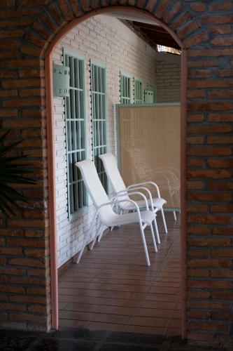 a pair of white chairs sitting on a porch at Hotel Flor de Maria in Puerto Escondido