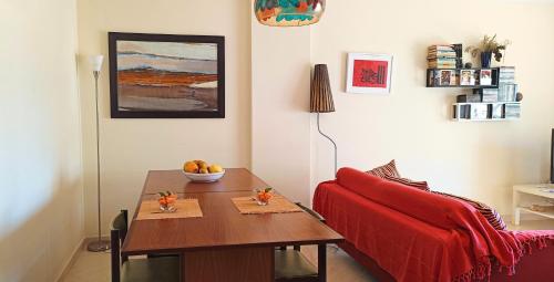 a living room with a table and a red couch at Island Escape - Blue Residence in Conceição