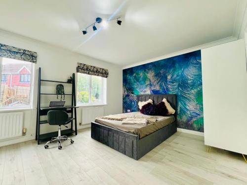 a bedroom with a bed and a painting on the wall at Anjaneya Homes - Double Room En-suites with Kitchenette in Ashford