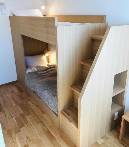 a bunk bed in a room with a staircase at MY LODGE Naoshima in Naoshima
