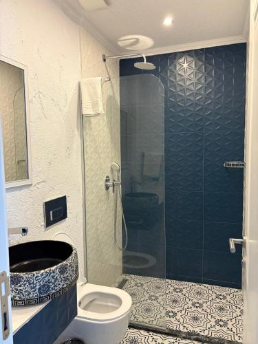 a bathroom with a toilet and a glass shower at AKSOY TAŞ EV in Bodrum City